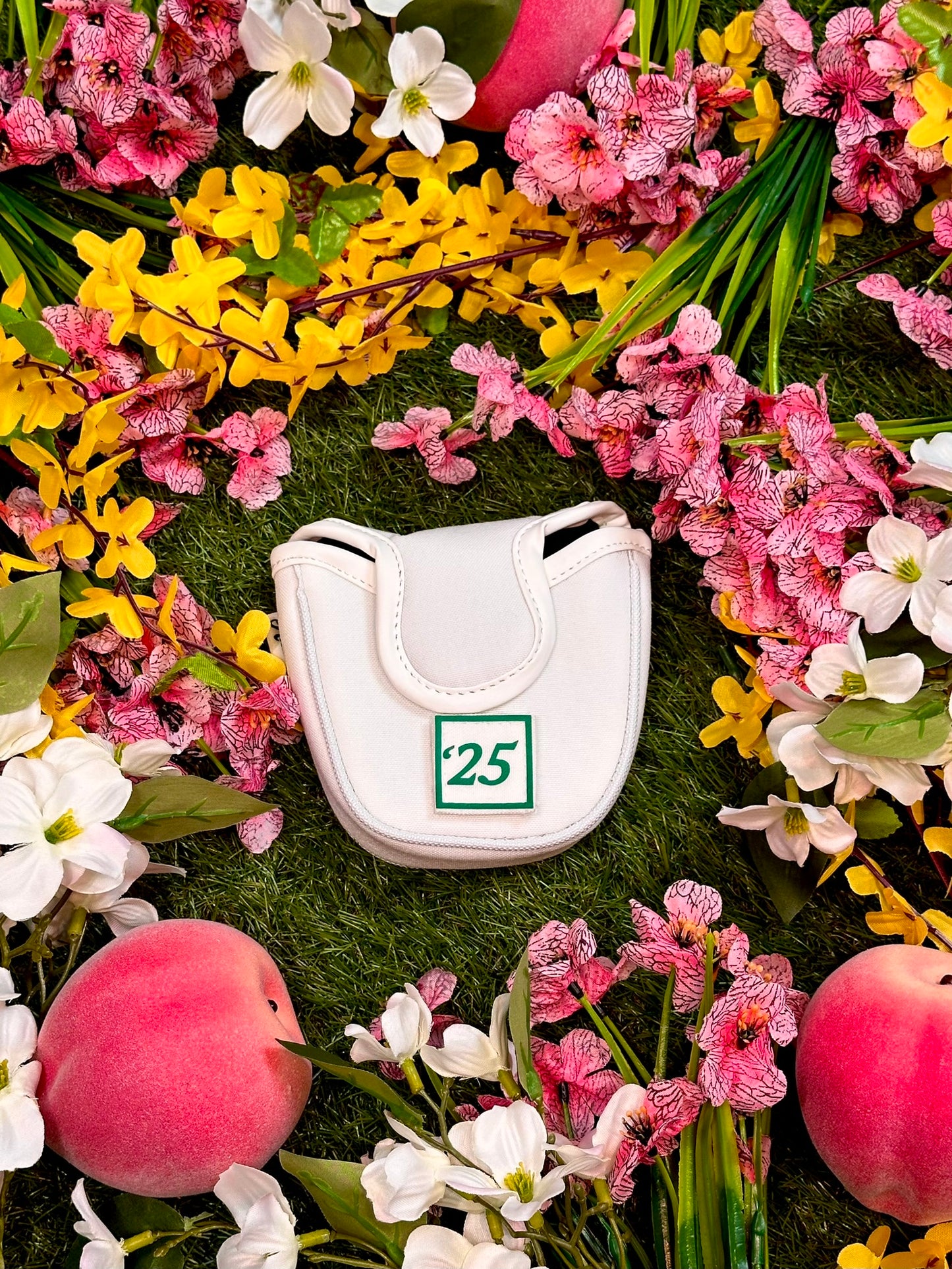 White golf club head cover with number 25 surrounded by colorful flowers and peaches.