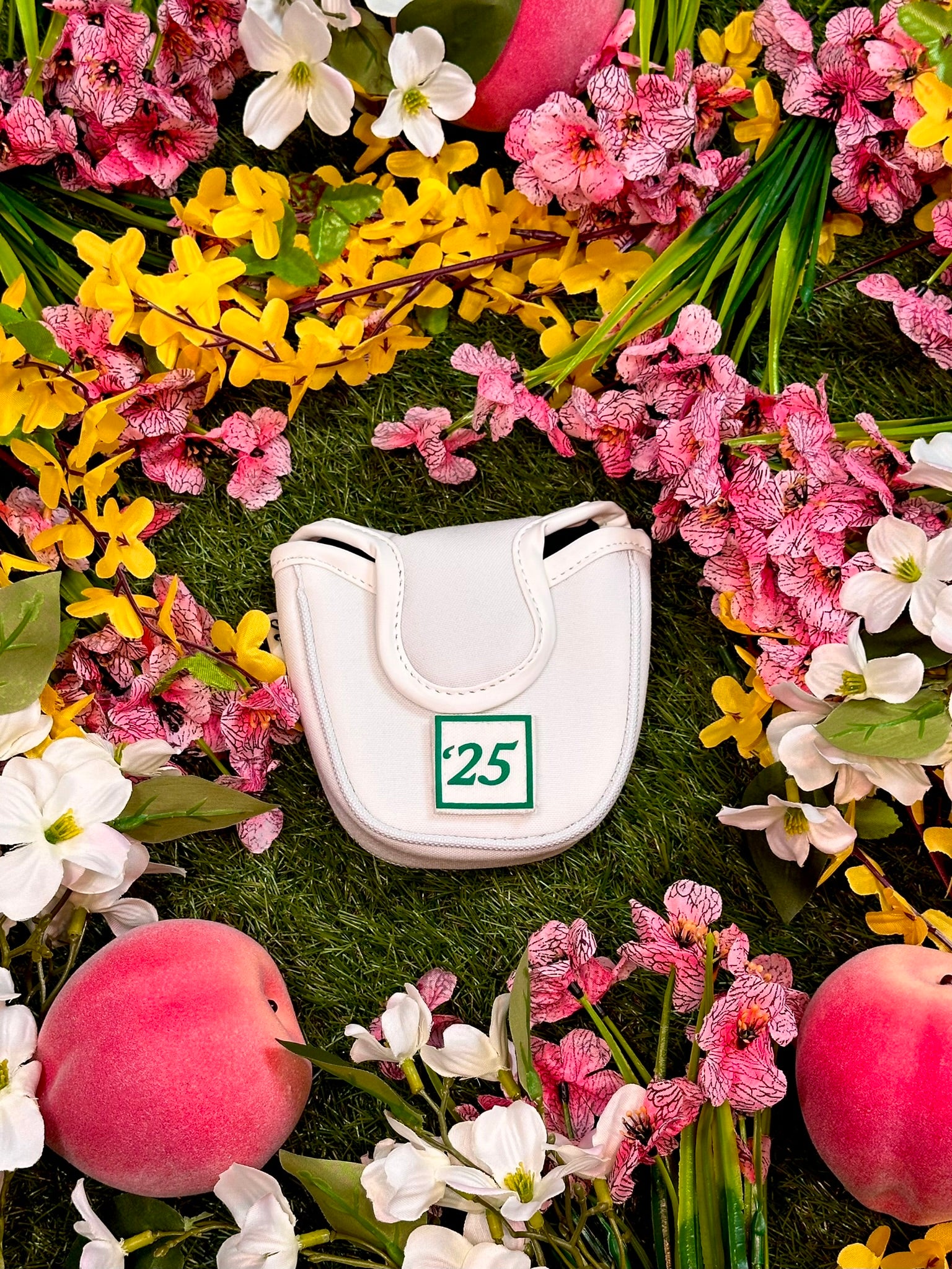 White golf club head cover with number 25 surrounded by colorful flowers and peaches.
